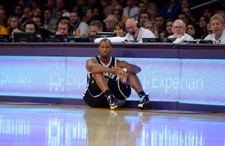 Jason Collins sitting on a basketball court