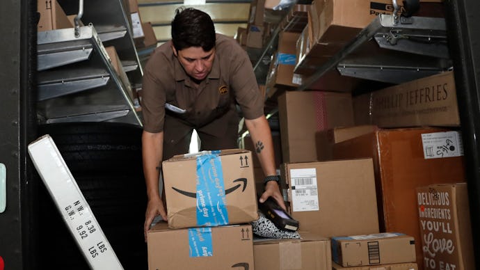 A UPS employee taking holiday gift packages and Amazon boxes out of the delivery van