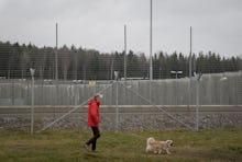 A man walking his dog next to a closed prison in Sweden