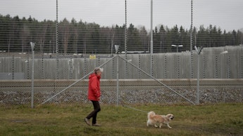 A man walking his dog next to a closed prison in Sweden