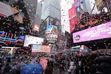 The moment of the New Year's Eve ball drop on TV with a large crowd of people