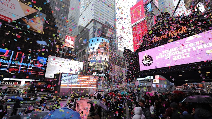 The moment of the New Year's Eve ball drop on TV with a large crowd of people