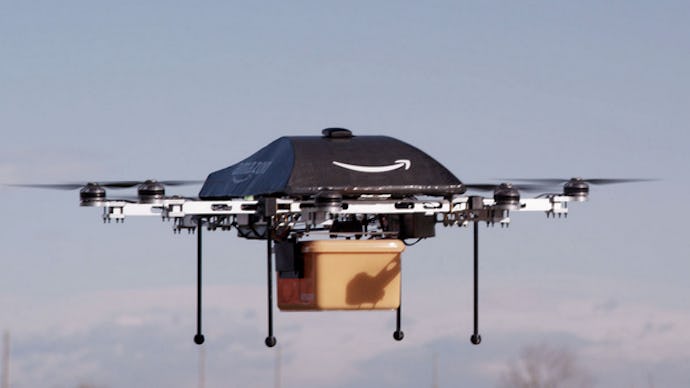 A black Amazon drone in the air, delivering a package
