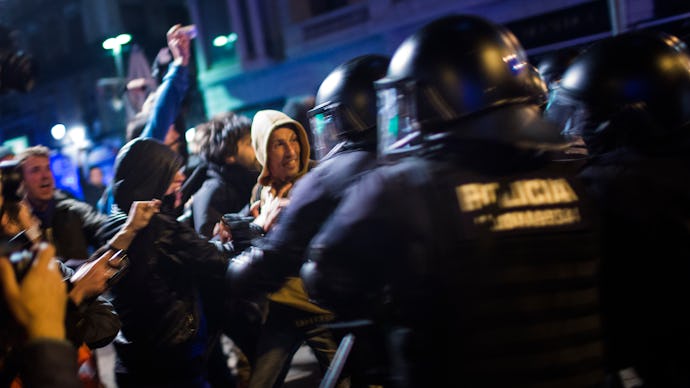 Young people protesting next to policemen