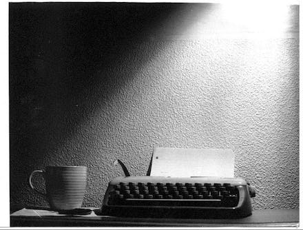A typing machine and a mug on a desk with a black and white color filter