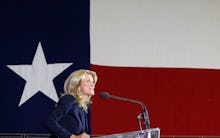 Wendy Davis giving a speech at a podium in front of a texas flag