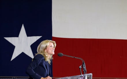 Wendy Davis giving a speech at a podium in front of a texas flag
