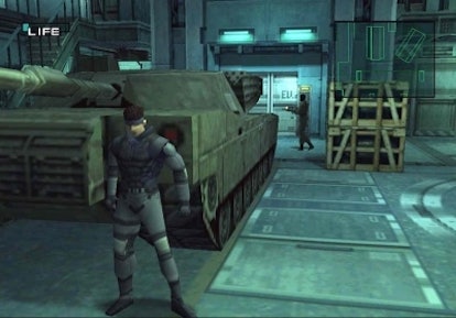 A screenshot from the video game 'Metal Gear Solid' of a character idling in a room with a large tan...