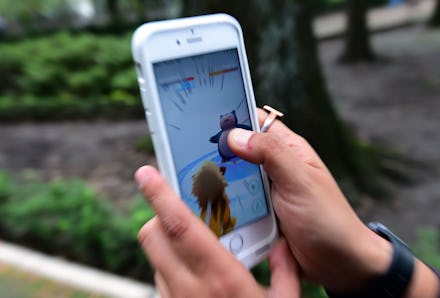 A person playing Pokémon Go on mobile phone in a park