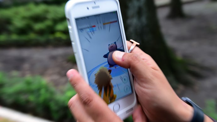 A person playing Pokémon Go on mobile phone in a park