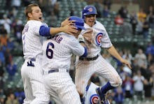 Chicago Cubs players hugging and jumping up and down in celebration