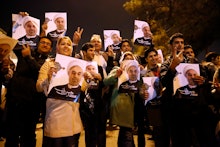 Iranians holding posters of President Hassan Rouhani as they welcome Iranian nuclear negotiators upo...