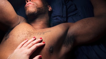 A hand with red nails stroking a man's body to show intimacy of an open relationship