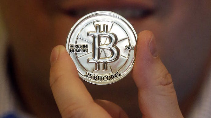 A man holding a silver printed out bitcoin