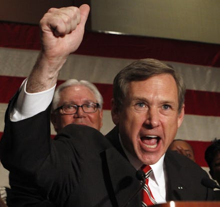 Mark Kirk with a raised arm, giving a speech about a nuclear deal with Iran