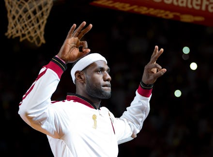 Lebron James in a white tracksuit, white head band holding up six fingers