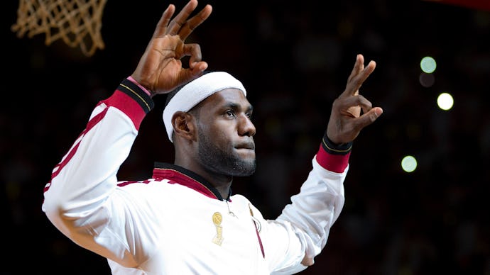 Lebron James in a white tracksuit, white head band holding up six fingers