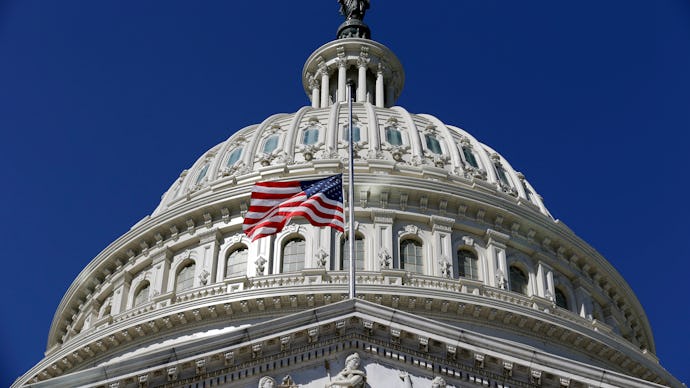 The United States Capitol with an american flag on a bright sunny day