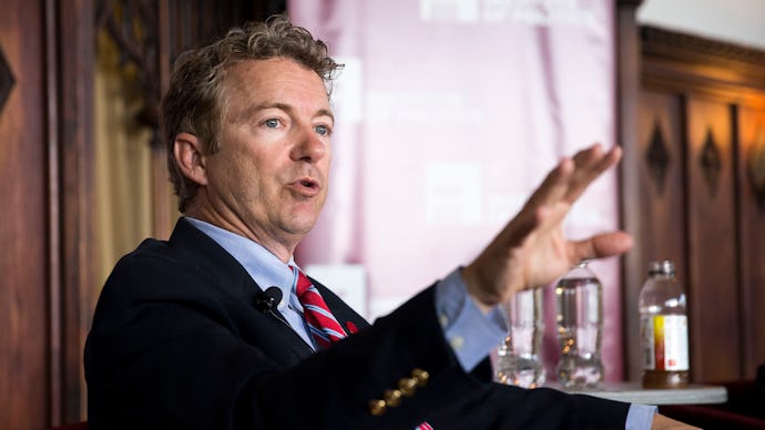Senator Rand Paul in a suit and tie sitting in a chair giving an interview