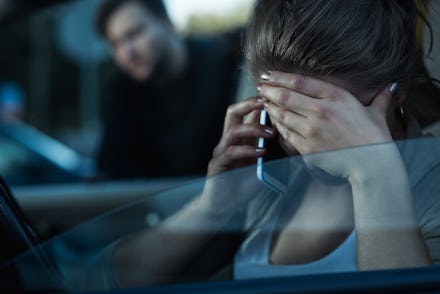 A woman speaking on her phone with installed spyware that empowers abusers and leaves her vulnerable