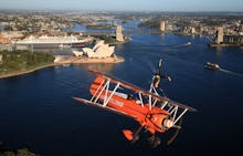 An orange helicopter flying over Sydney