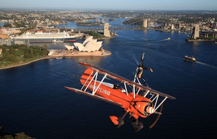 An orange helicopter flying over Sydney