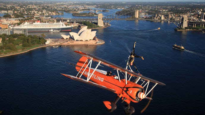 An orange helicopter flying over Sydney