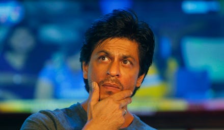 Shah Rukh Khan, famous Bollywood actor, posing with his hand on his chin, looking off into the dista...