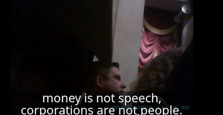 Protester standing up to Supreme Court saying that money isn't speech & corporations aren't people