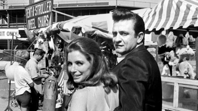 Johnny Cash hugging a woman as they walk through a fair 