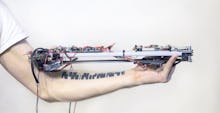 A man holding a machine that can read tattoos and play music