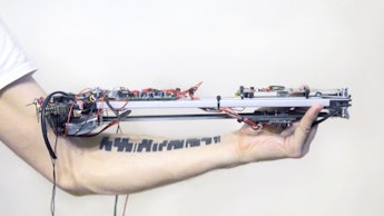 A man holding a machine that can read tattoos and play music