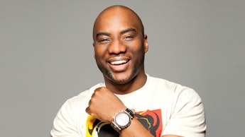 Charlamagne Tha God posing in a white shirt and smiling 
