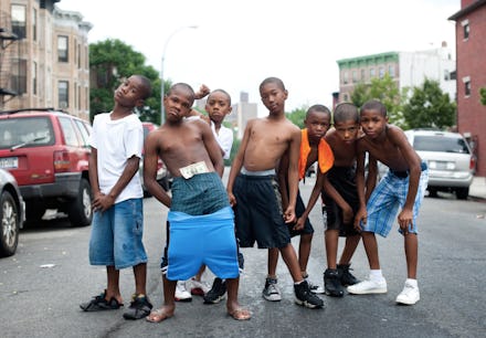 Seven boys posing for a photo in the middle of a street