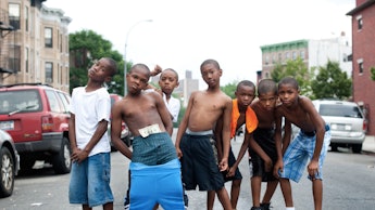 Seven boys posing for a photo in the middle of a street