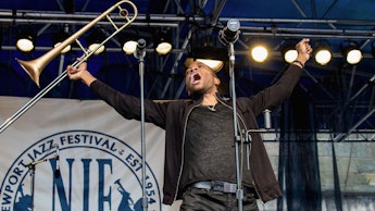 A man holding his trombone in the air at the Newport Jazz Festival 