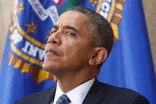 Obama standing in front of a flag with his head raised up