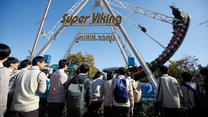 People in an amusement park waiting in line for a roller coaster ride at the Korean DMZ