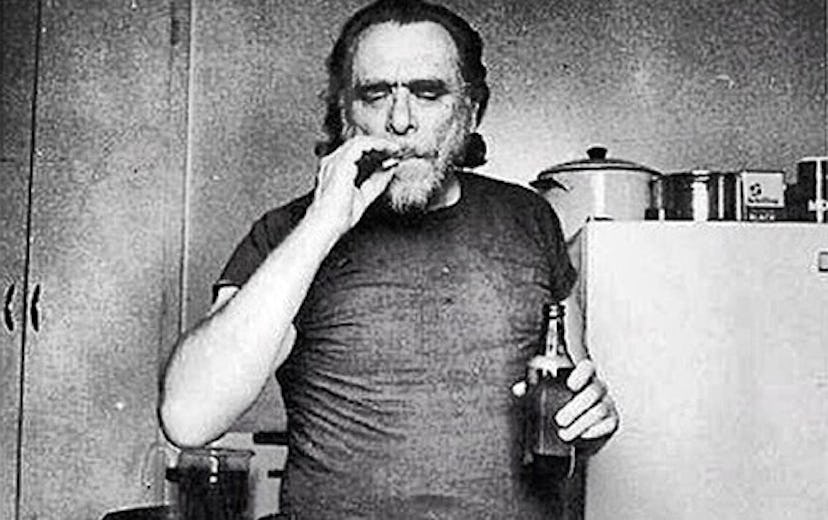 Colorless photograph of Charles Bukowski smoking a cigarette and holding beer