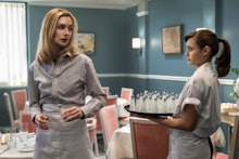 Caitlin FitzGerald standing in a restaurant playing a waitress on tv