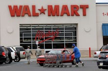 A walmart employee collecting shopping carts in the parking lot