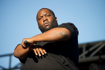 The rapper Killer Mike in a black shirt holding a microphone while performing on stage