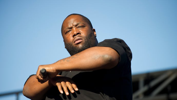 The rapper Killer Mike in a black shirt holding a microphone while performing on stage