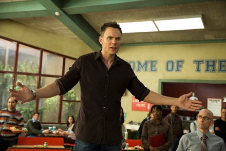 Joel McHale in Season 5 of Community standing in the cafeteria, spreading his arms with a frustrated...
