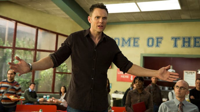 Joel McHale in Season 5 of Community standing in the cafeteria, spreading his arms with a frustrated...