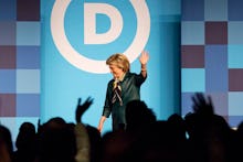 Hillary Clinton waving at the audience after finishing her speech at a political rally