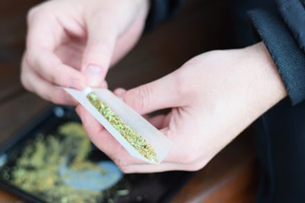 A person putting marijuana into rice paper and rolling it up