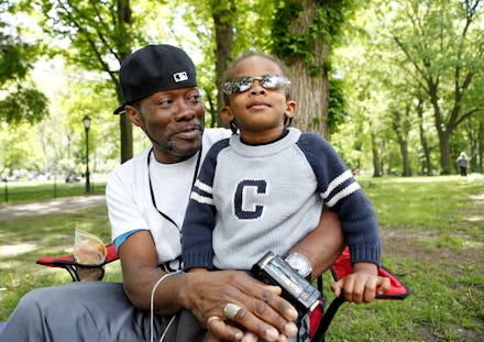 A father sitting on the grass with his son in a park