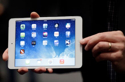A person holding an iPad with a home screen opened