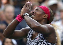 Serena Williams pressing her hands together in gratitude with her eyes closed, in a leopard top and ...